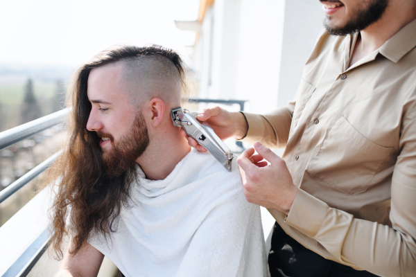 Haircut on a balcony at home, coronavirus and lockdown concept.