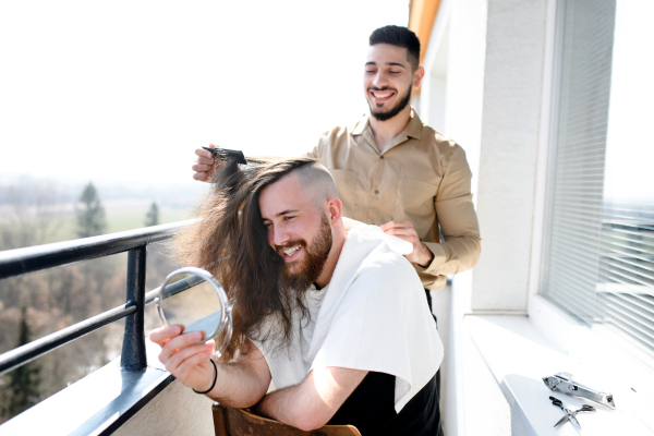 Haircut on a balcony at home, coronavirus and lockdown concept.