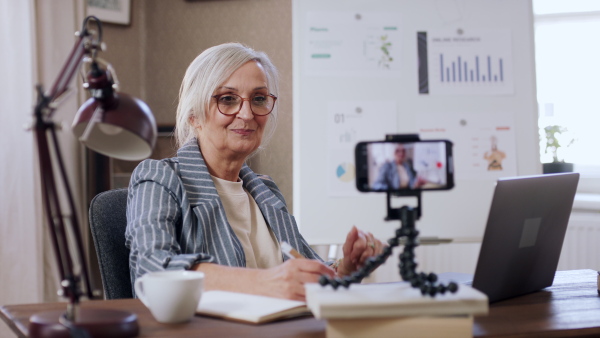 A senior woman streaming an online presentation. Lockdown concept.