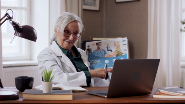 A senior woman doing an online presentation about vaccination. Lockdown concept.