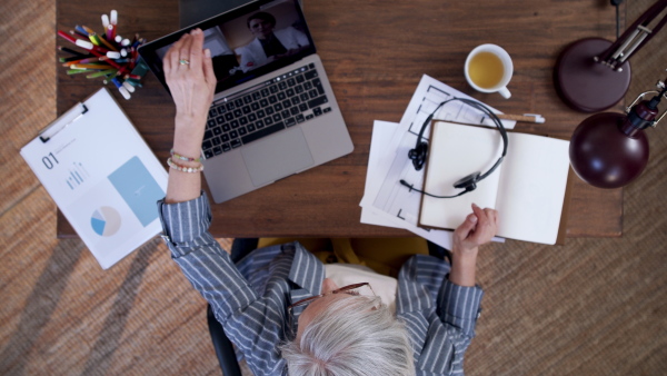 A top view of frustrated senior woman ending an online video call. Lockdown concept.