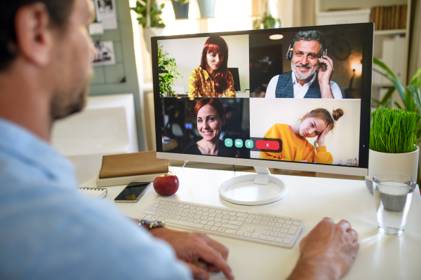 Unrecognizable businessman having video call on computer at home.