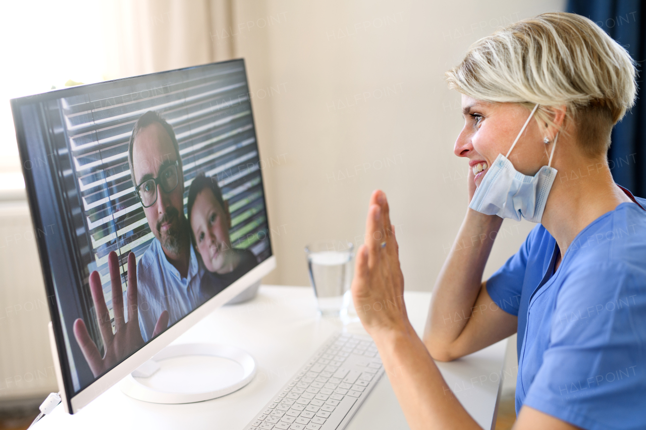 Side view of woman doctor having video call with patients on laptop, online consultation concept.