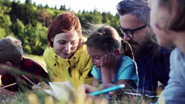 A group of small school children with teacher on field trip in nature. Slow motion.