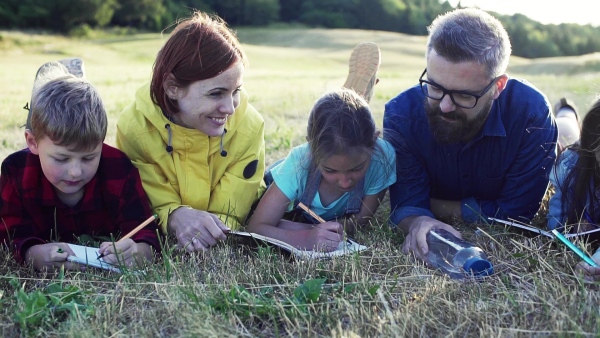 A group of small school children with teacher on field trip in nature. Slow motion.