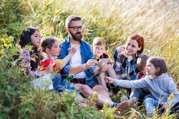 A group of small school children with teacher on field trip in nature.