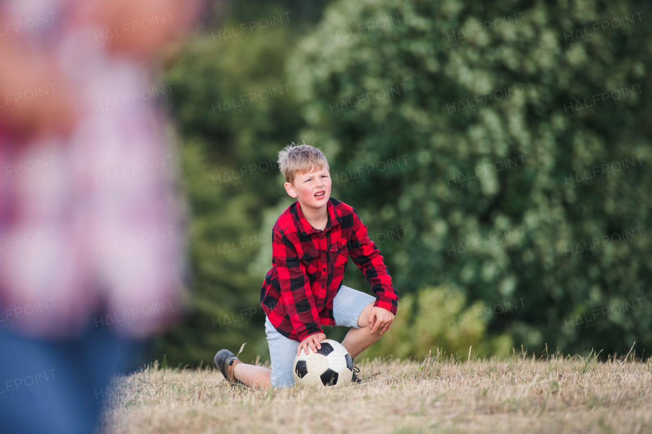 School children standing on field trip in nature, playing with a ball. Copy space.