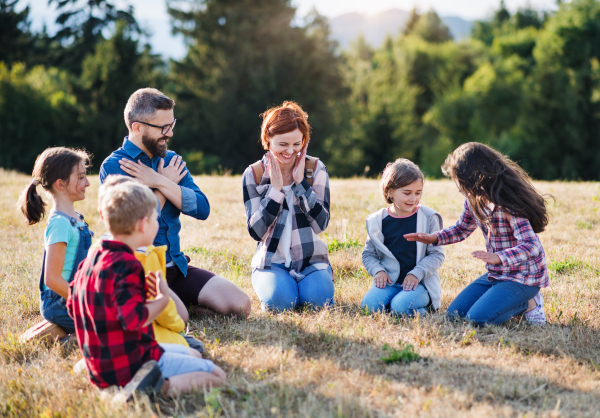 A group of small school children with teacher on field trip in nature.