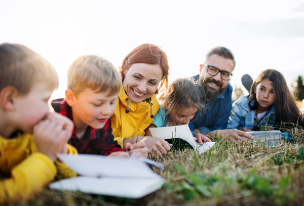 A group of small school children with teacher on field trip in nature.