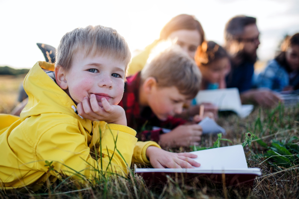 A group of small school children with teacher on field trip in nature.