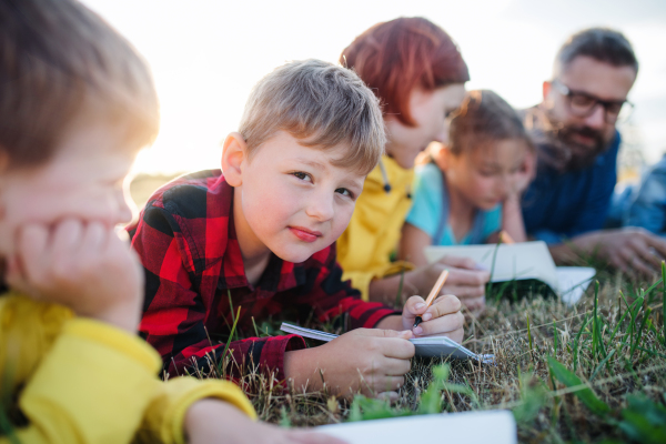 A group of small school children with teacher on field trip in nature.