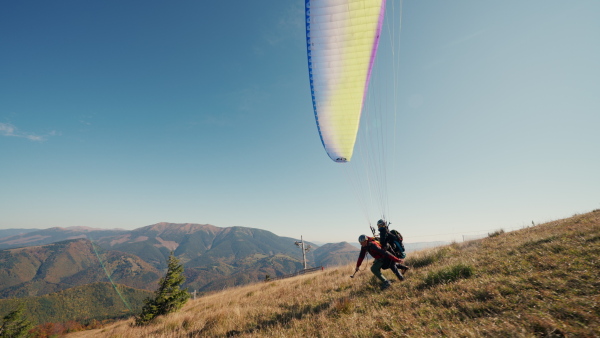 Paragliders are preparing for the flight on a mountain. Extreme sports activity.