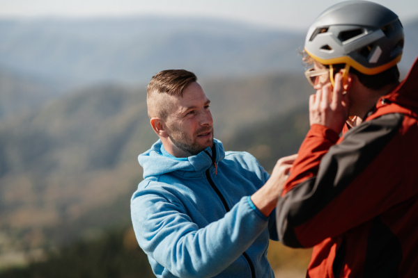 A paraglider is preparing for flight, putting on helmet.