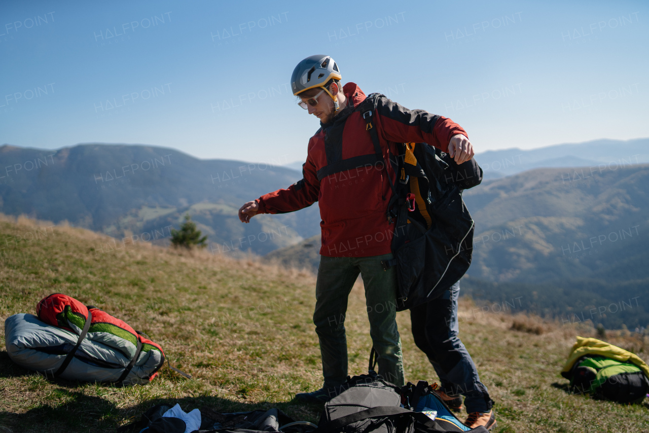 A man helping paragliding pilot to prepare for flight.