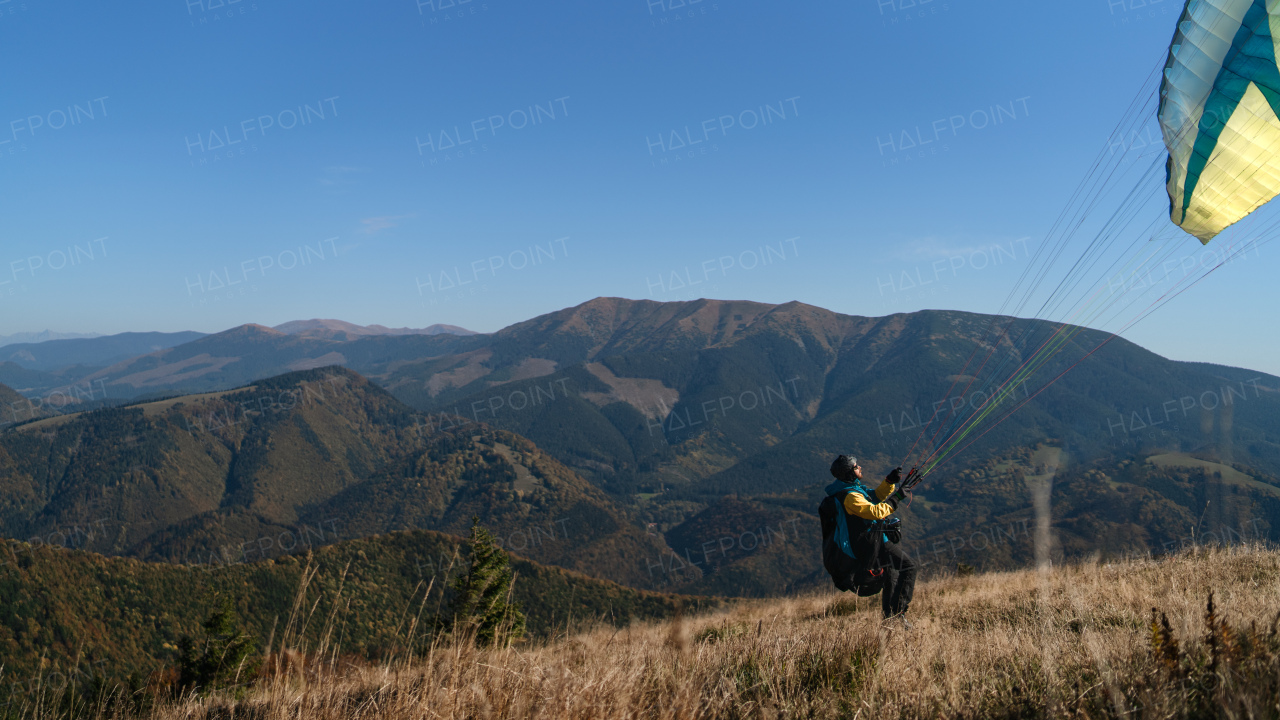 A paraglider landing on the ground against the blue sky.