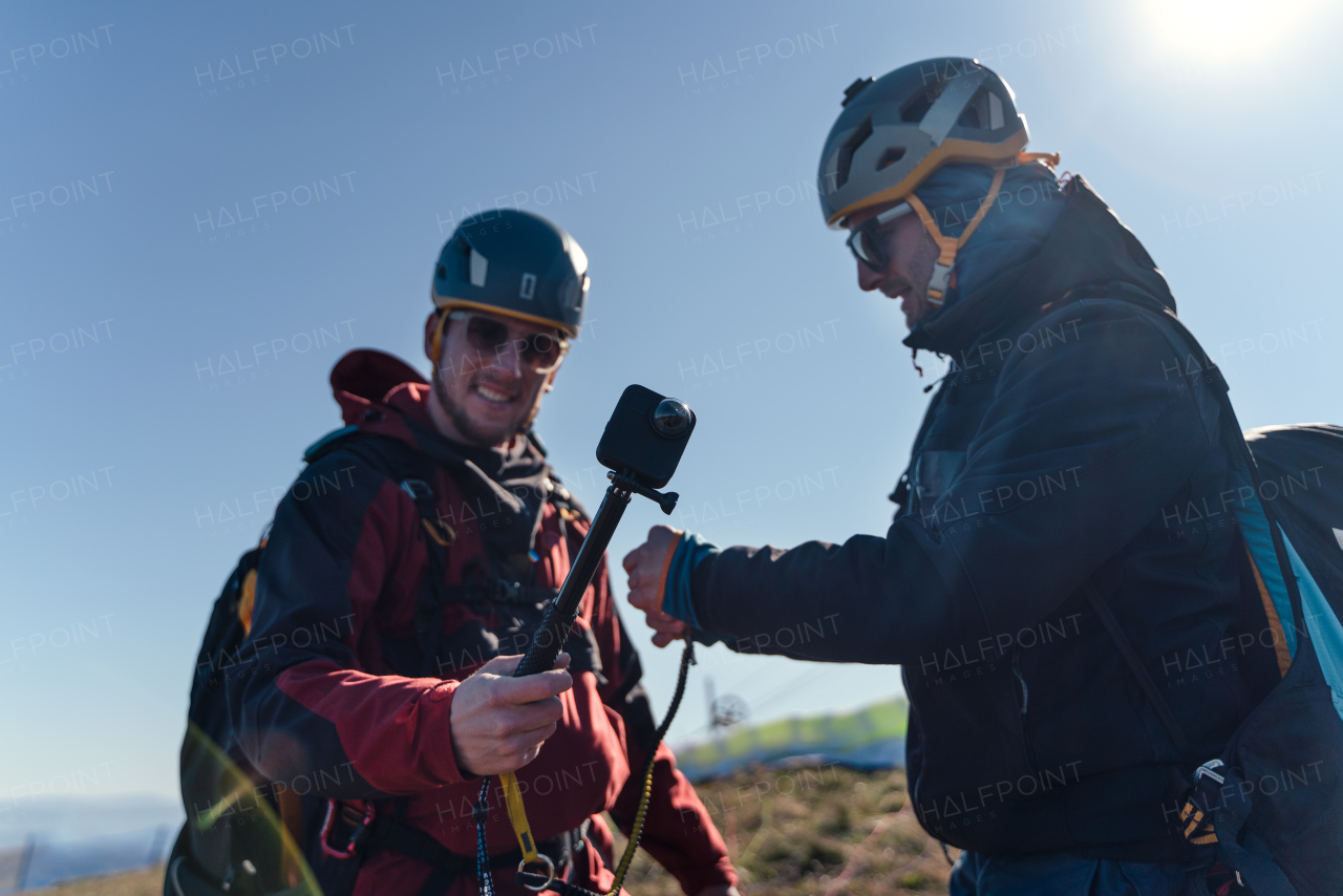 A man helping paragliding pilot to prepare for flight.