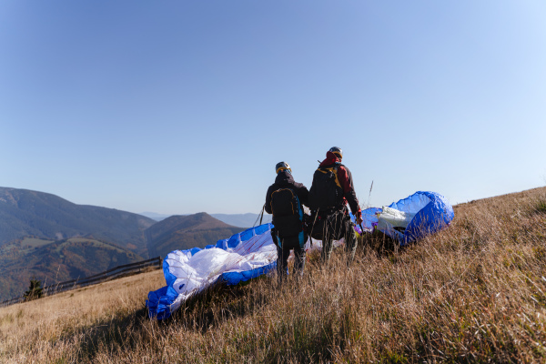 A paraglider is preparing for the flight on mountain. Extreme sports activity.