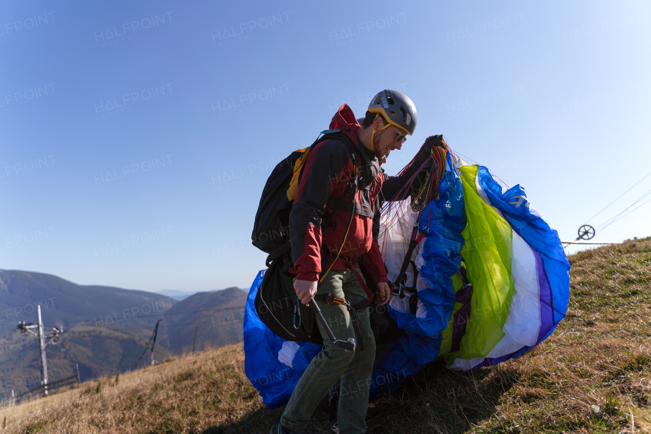 Paragliders preparing for flight in mountain. Extreme sports activity.