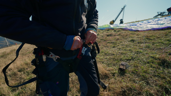 A paraglider is preparing for a flight, close-up