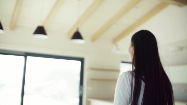 An excited young woman in new home, spinning. A moving in new home concept. Slow motion.