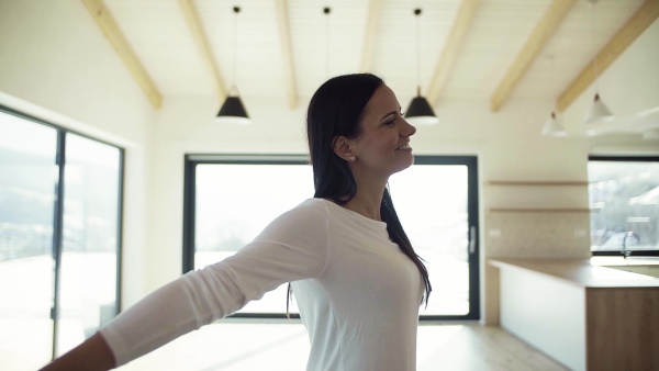 An excited young woman in new home, spinning. A moving in new home concept. Slow motion.