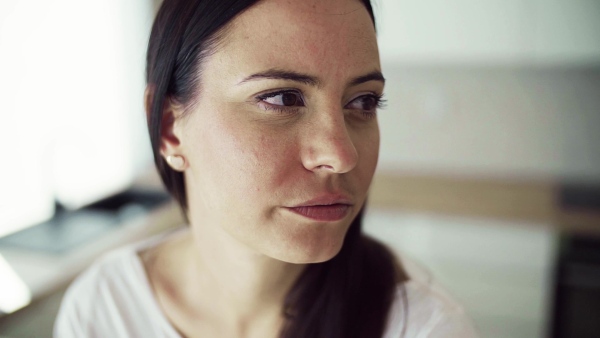 A close-up portrait of young woman indoors in new home. Slow motion.