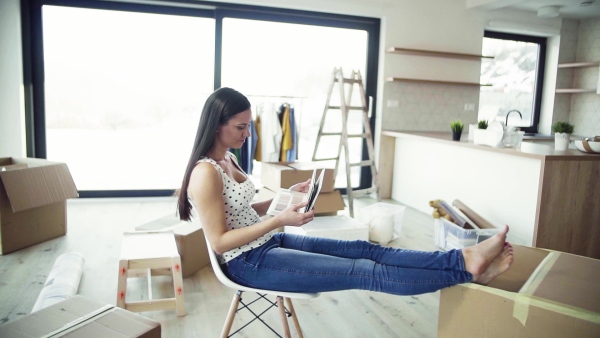 A young woman moving in new home, looking at color swatch. A moving in new home concept. Slow motion.