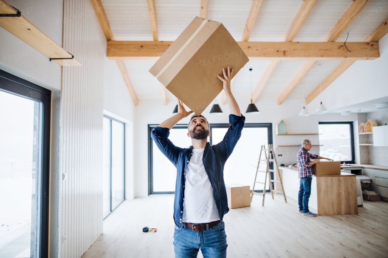 A portrait of mature man with his senior father furnishing new house, a new home concept. Copy space.