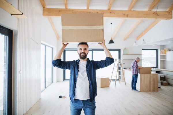 A portrait of mature man with his senior father furnishing new house, a new home concept. Copy space.