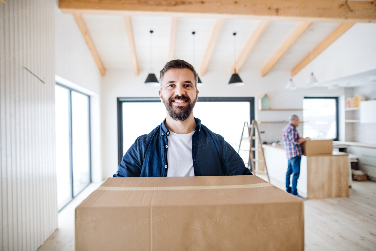 A portrait of mature man with his senior father furnishing new house, a new home concept. Copy space.