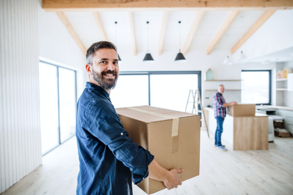 A portrait of mature man with his senior father furnishing new house, a new home concept. Copy space.