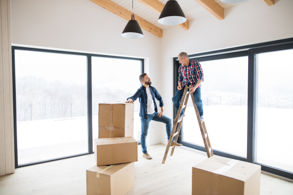 A mature man with his senior father furnishing new house, a new home concept. Copy space.