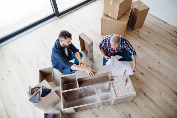 A top view of mature man with his senior father assembling furniture, a new home concept.