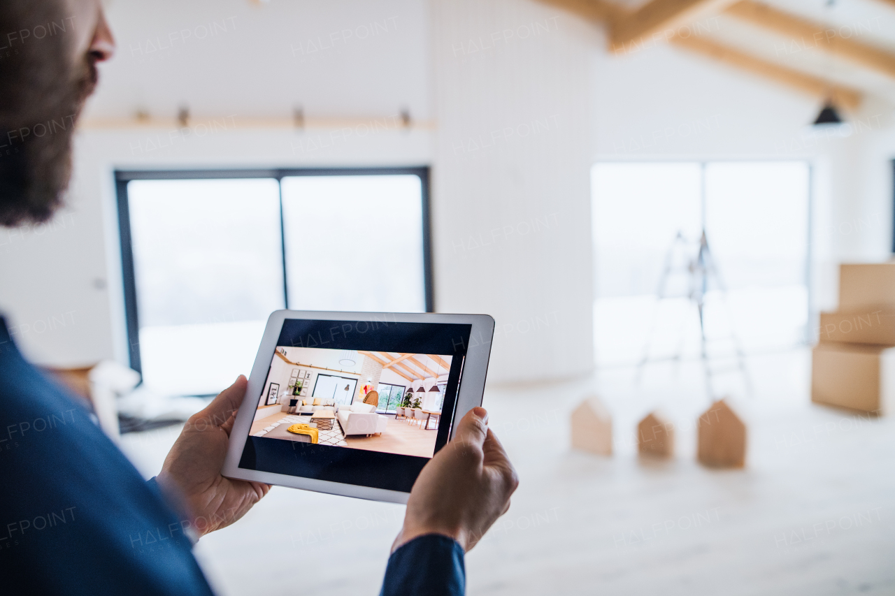 A midsection of man with tablet, looking at interior design sketches. A new home concept.