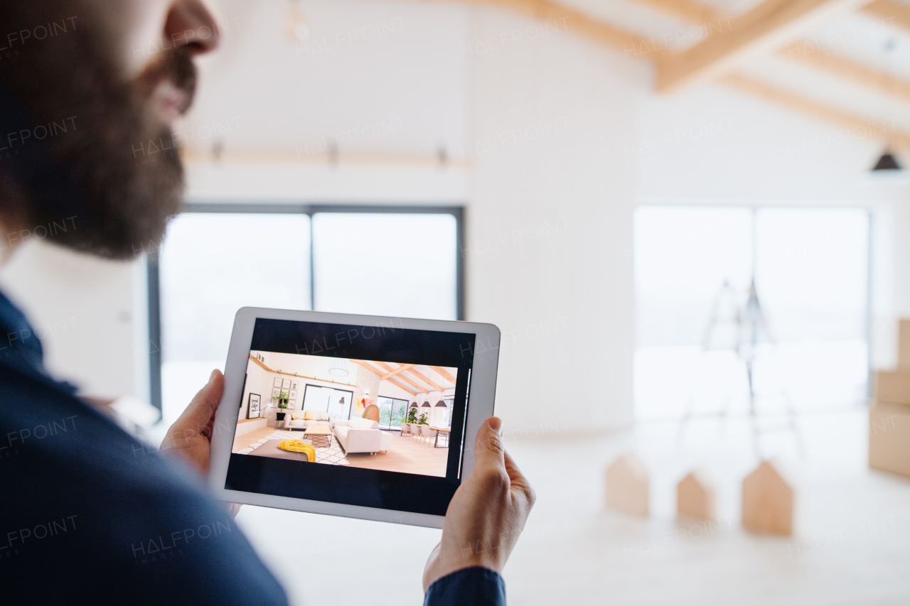 A midsection of man with tablet, looking at interior design sketches. A new home concept.