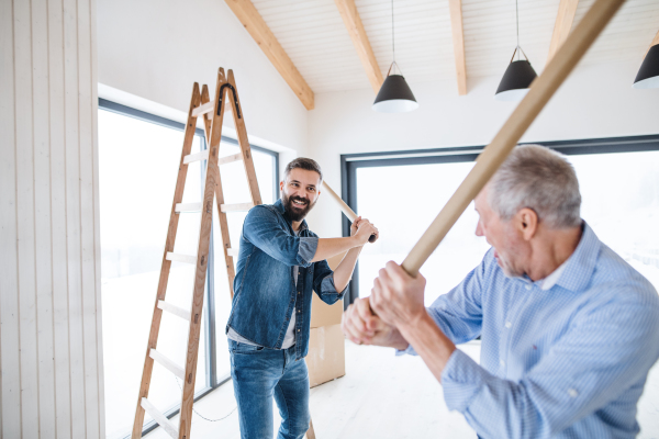 Two cheerful men having fun when furnishing new house, a new home concept.