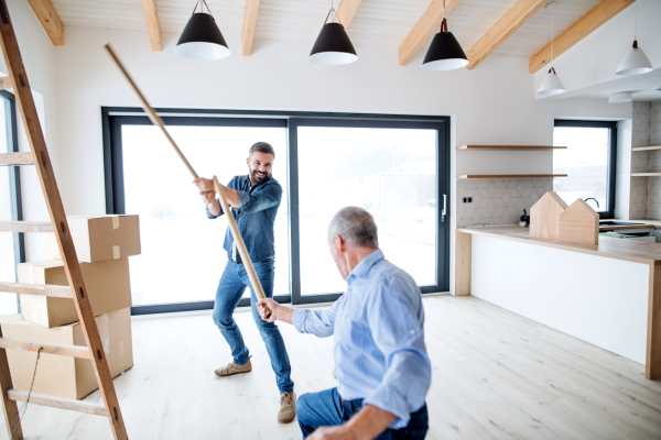 Two cheerful men having fun when furnishing new house, a new home concept.