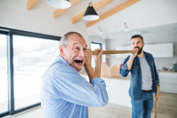 Two cheerful men having fun when furnishing new house, a new home concept.