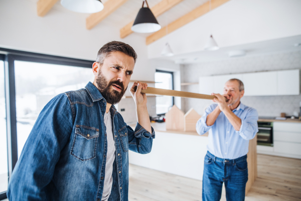 Two cheerful men having fun when furnishing new house, a new home concept.