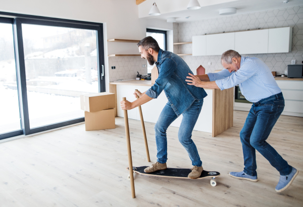 Two cheerful men having fun when furnishing new house, a new home concept.