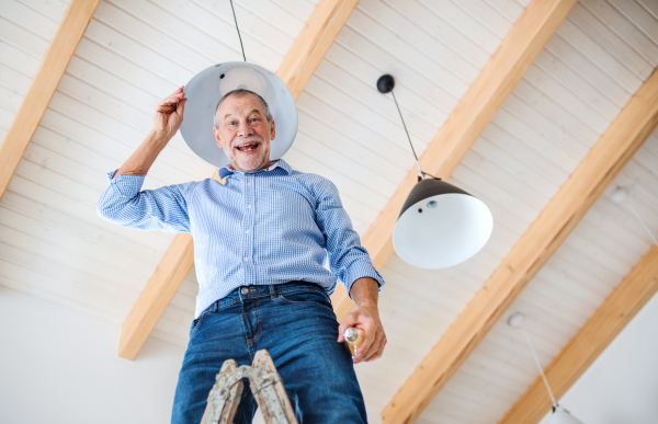 A low angle view of senior man furnishing new house, having fun. A new home concept.