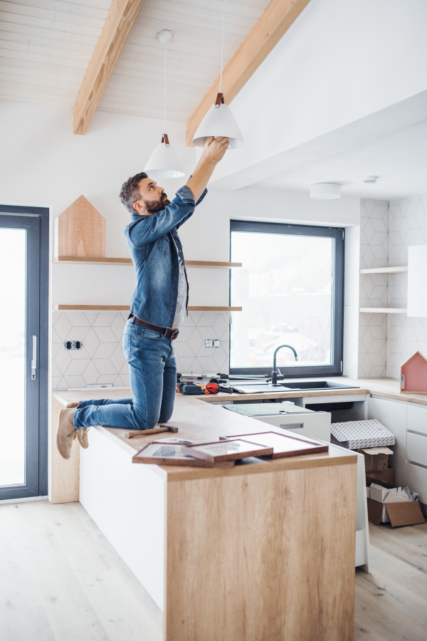 A cheerful mature man furnishing new house, a new home concept.