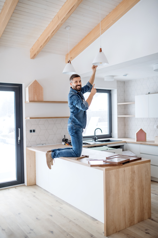 A cheerful mature man furnishing new house, a new home concept.