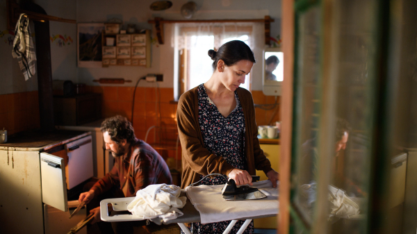 Portrait of poor mature couple indoors in kitchen at home, poverty concept.