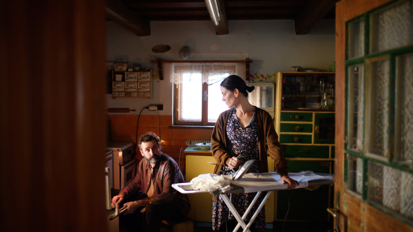 Portrait of poor mature couple indoors in kitchen at home, poverty concept.