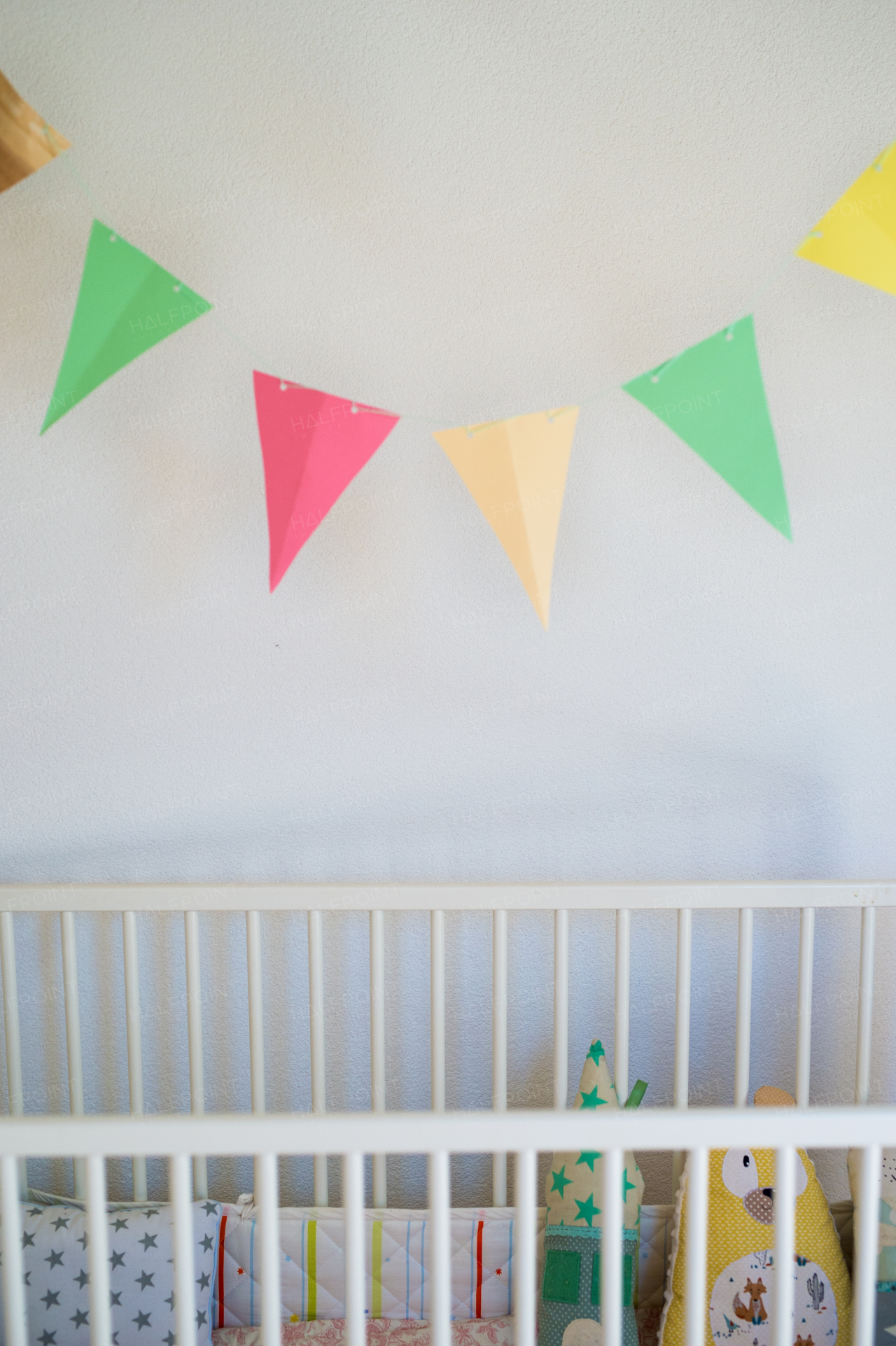 Cot in bedroom decorated for newborn baby. Copy space.