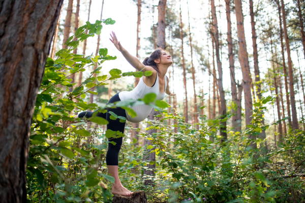 Side view portrait of happy pregnant woman outdoors in nature, doing exercise.