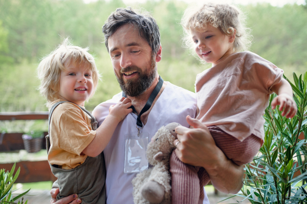 Happy father doctor finally at home meeting his small children, end of coronavirus.