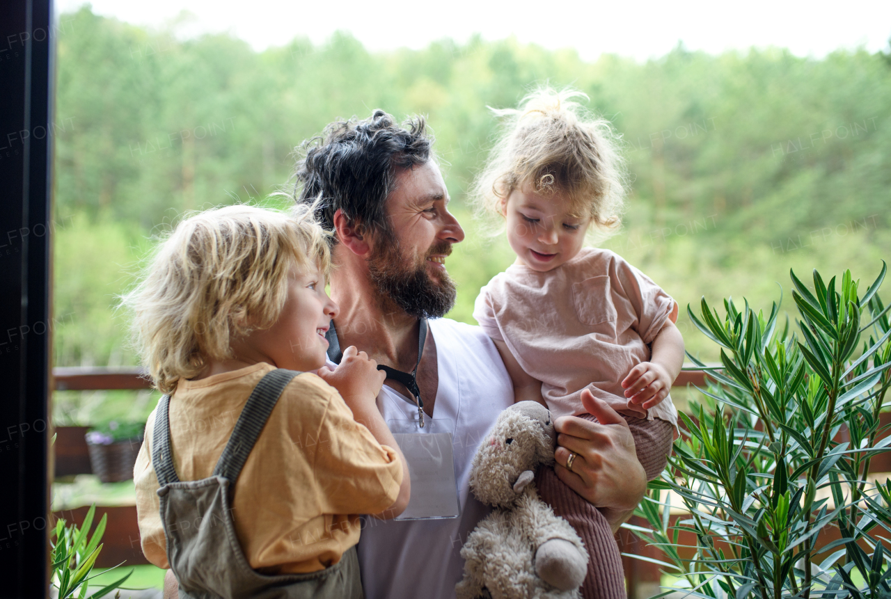 Happy father doctor finally at home meeting his small children, end of coronavirus.