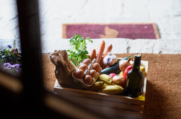 Top view of wooden box with food shopping at the doorstep, corona virus and quarantine concept.